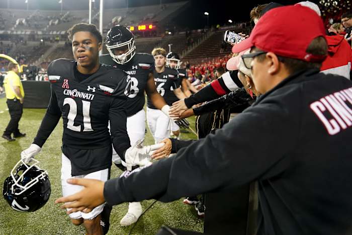 Nov 5, 2022; Cincinnati, Ohio, USA; Cincinnati Bearcats wide receiver Tyler Scott (21) high fives fans after defeating the Navy Midshipmen at Nippert Stadium. Cincinnati won 20-10. Mandatory Credit: Kareem Elgazzar/Cincinnati Enquirer via USA TODAY NETWORK